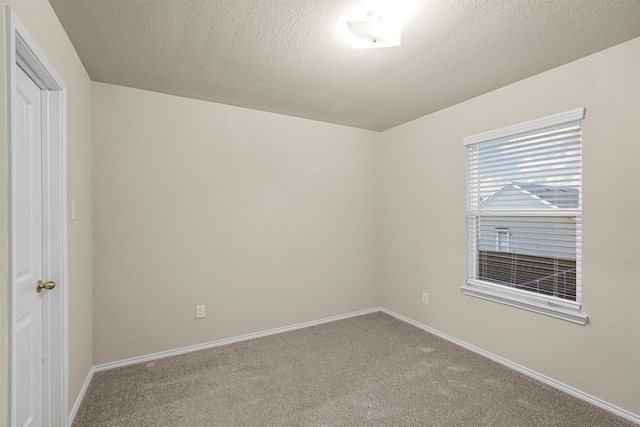 carpeted spare room with a textured ceiling