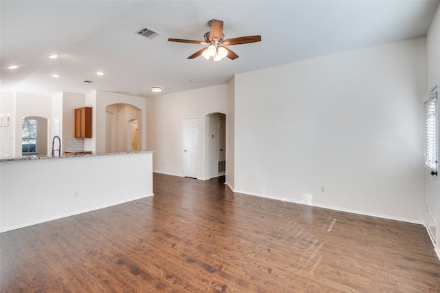 unfurnished living room with ceiling fan, dark hardwood / wood-style flooring, and sink