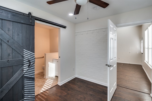 interior space featuring a barn door and dark wood-type flooring