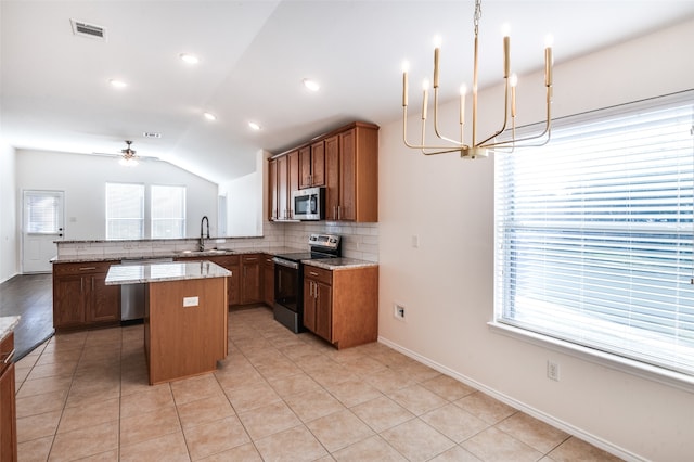 kitchen featuring kitchen peninsula, ceiling fan with notable chandelier, stainless steel appliances, vaulted ceiling, and sink