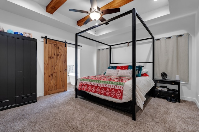 carpeted bedroom featuring beamed ceiling, a barn door, ensuite bathroom, and ceiling fan