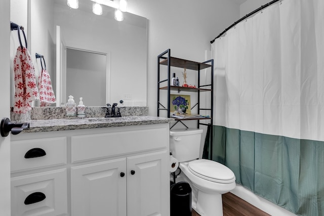 bathroom with vanity, hardwood / wood-style flooring, toilet, and curtained shower