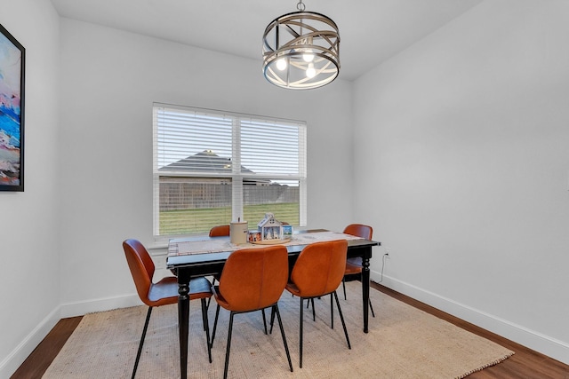 dining area with hardwood / wood-style flooring and a chandelier