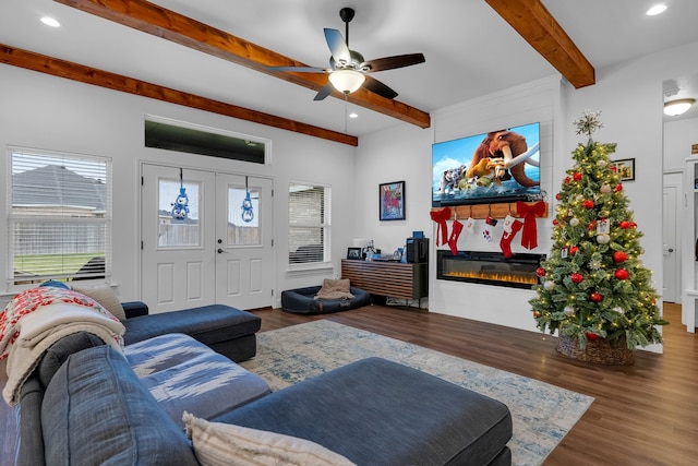 living room featuring beamed ceiling, hardwood / wood-style flooring, and ceiling fan