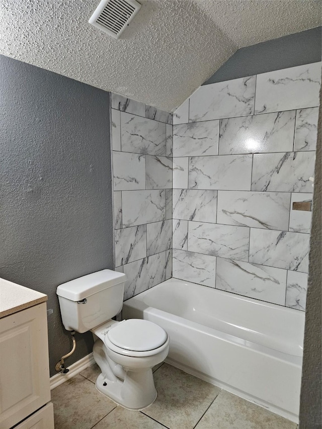 full bathroom featuring vanity, tile patterned floors, tiled shower / bath, toilet, and a textured ceiling