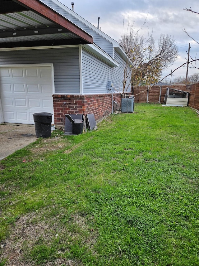 view of yard featuring central air condition unit and a garage