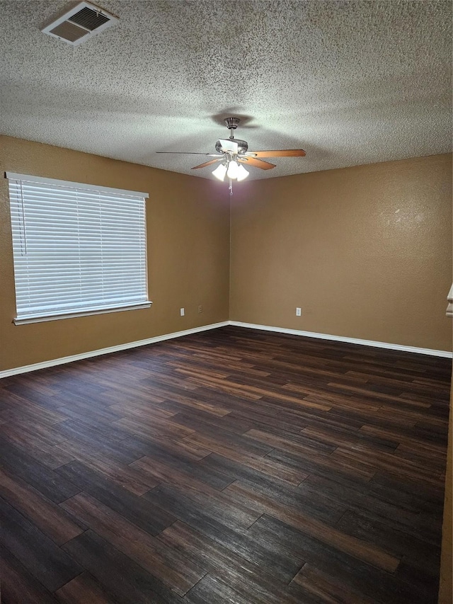 spare room featuring dark wood-type flooring, a textured ceiling, and ceiling fan