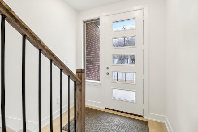 foyer with stairs, light wood finished floors, and baseboards