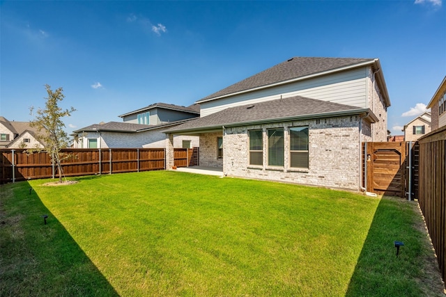 back of house with a yard and a patio