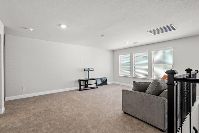 sitting room with light colored carpet and a textured ceiling