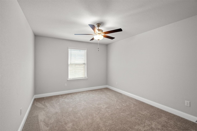 carpeted empty room with ceiling fan and a textured ceiling