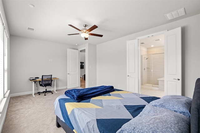 bedroom with multiple windows, ceiling fan, ensuite bathroom, and light carpet