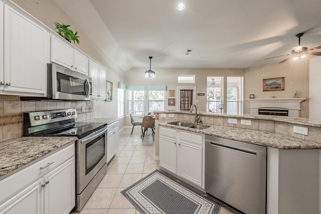 kitchen featuring pendant lighting, sink, backsplash, stainless steel appliances, and white cabinets