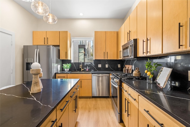 kitchen with light brown cabinetry, pendant lighting, stainless steel appliances, light hardwood / wood-style floors, and decorative backsplash