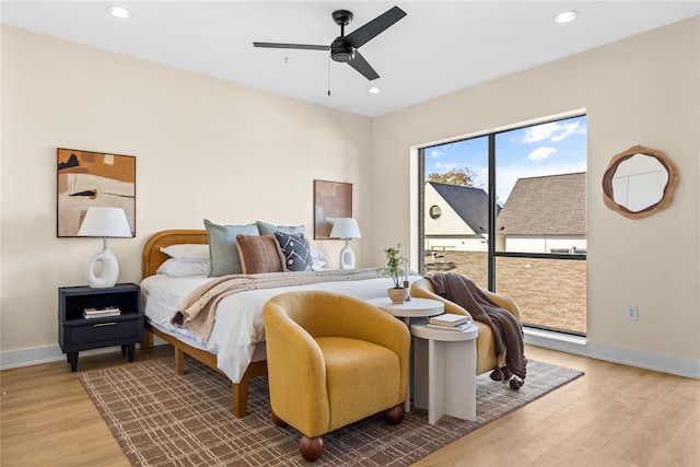 bedroom with hardwood / wood-style floors, access to outside, and ceiling fan