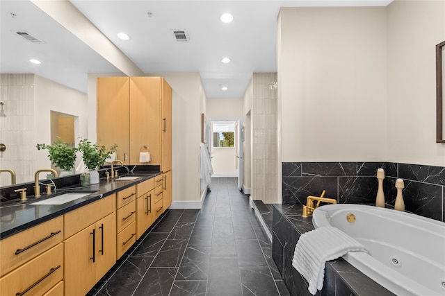 bathroom featuring vanity and tiled tub