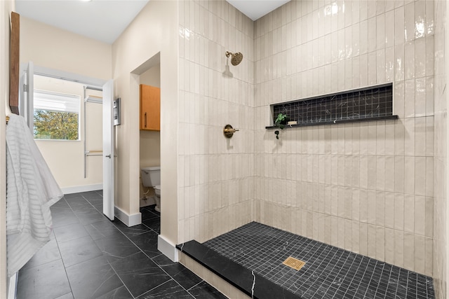 bathroom with toilet and tiled shower