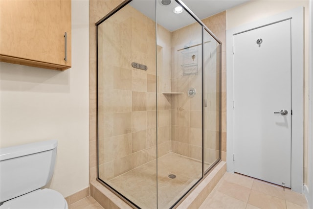 bathroom featuring walk in shower, tile patterned floors, and toilet