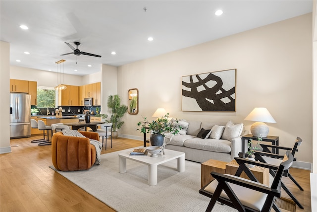 living room featuring light hardwood / wood-style flooring and ceiling fan