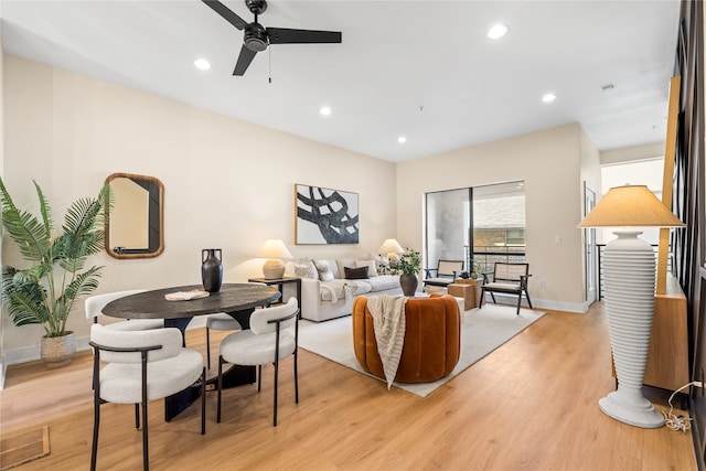 living room with ceiling fan and light hardwood / wood-style flooring