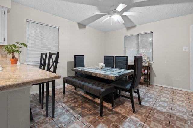 dining area with tile patterned floors, ceiling fan, and a textured ceiling