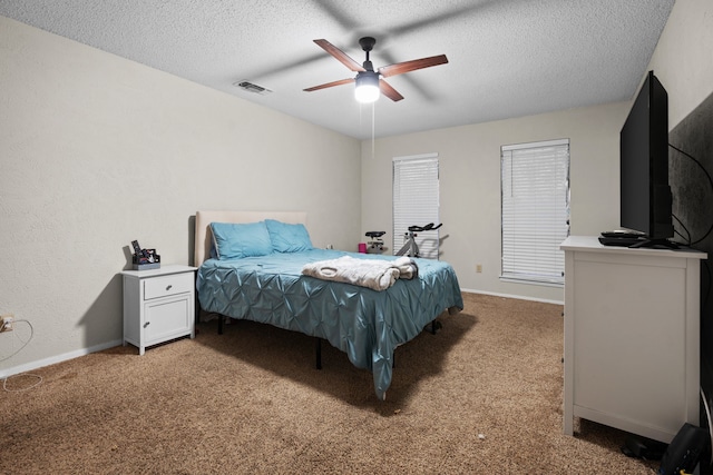 bedroom with a textured ceiling, carpet floors, and ceiling fan