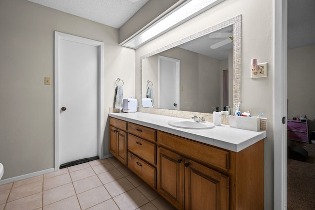 bathroom featuring tile patterned floors, vanity, ceiling fan, and a textured ceiling