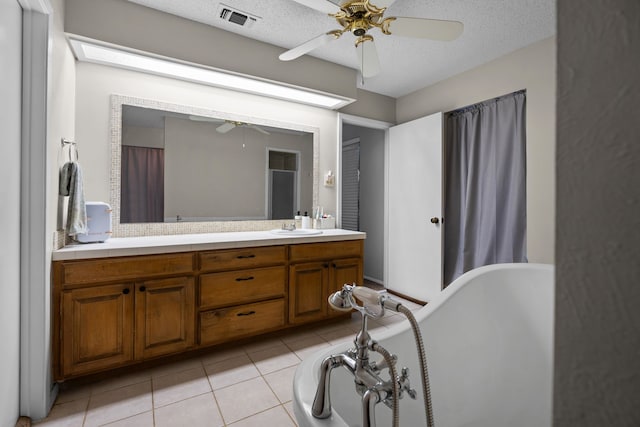 bathroom with ceiling fan, tile patterned flooring, vanity, and a textured ceiling