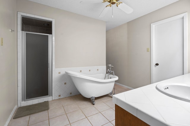 bathroom featuring tile patterned floors, vanity, a textured ceiling, and independent shower and bath