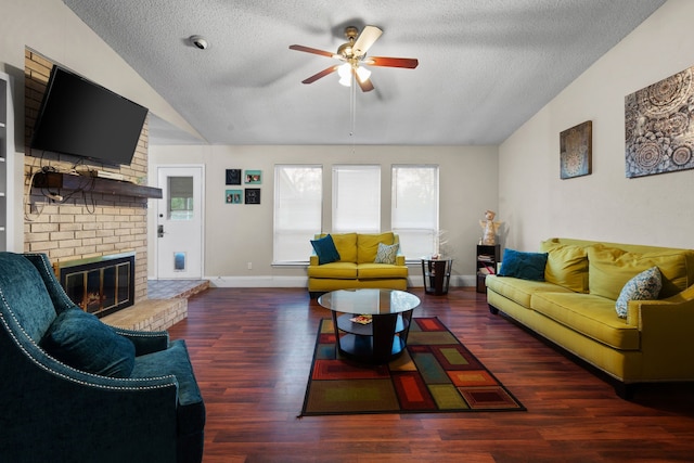 living room with a textured ceiling, dark hardwood / wood-style floors, vaulted ceiling, and ceiling fan