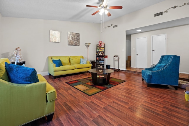 living room featuring ceiling fan, dark hardwood / wood-style flooring, lofted ceiling, and a textured ceiling