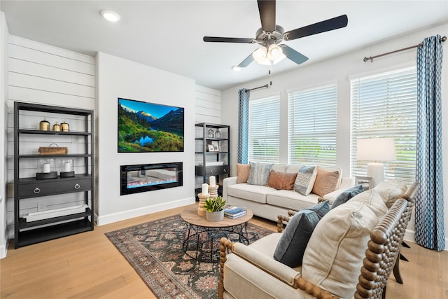 living room with ceiling fan and light wood-type flooring