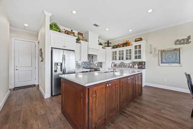 kitchen with tasteful backsplash, a large island, glass insert cabinets, appliances with stainless steel finishes, and a sink