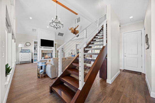 stairs with recessed lighting, a notable chandelier, a fireplace, wood finished floors, and baseboards