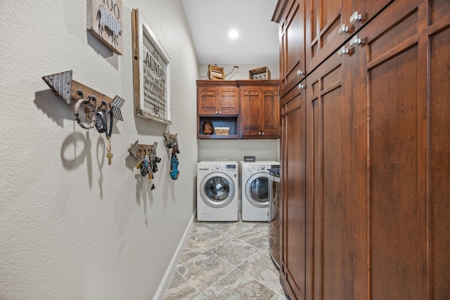 washroom featuring cabinet space, baseboards, and washing machine and clothes dryer