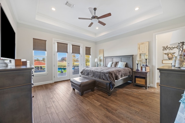 bedroom with access to outside, a tray ceiling, and visible vents