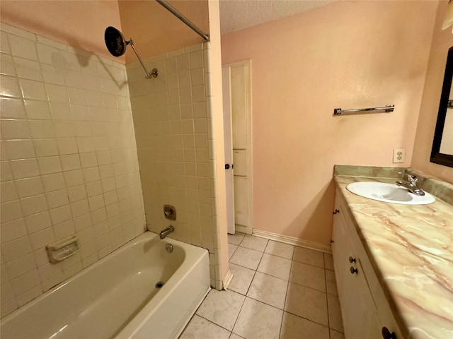 bathroom with tile patterned flooring, vanity, tiled shower / bath, and a textured ceiling