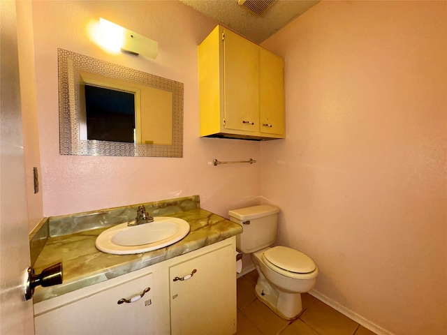 bathroom with tile patterned floors, vanity, a textured ceiling, and toilet