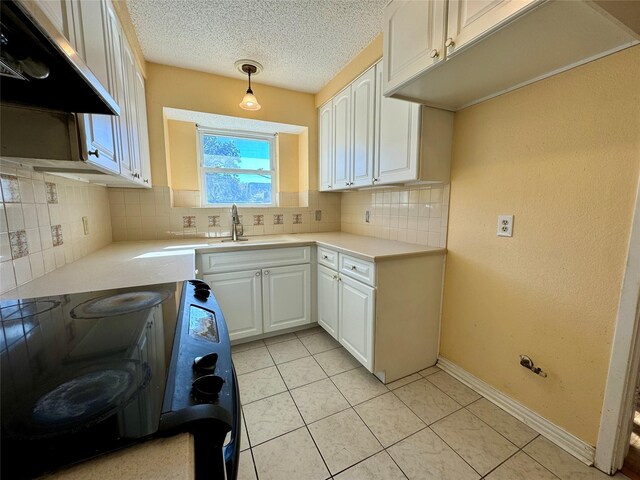 kitchen with white cabinetry, backsplash, stove, pendant lighting, and extractor fan