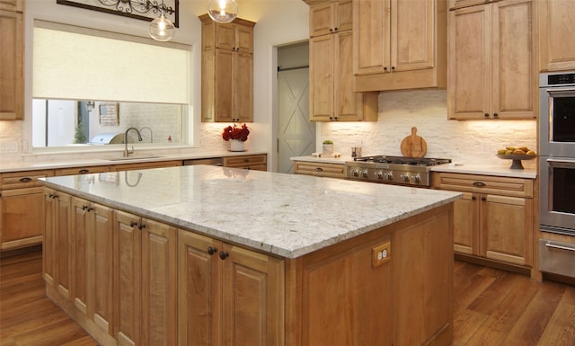 kitchen with a center island, sink, hanging light fixtures, light wood-type flooring, and appliances with stainless steel finishes