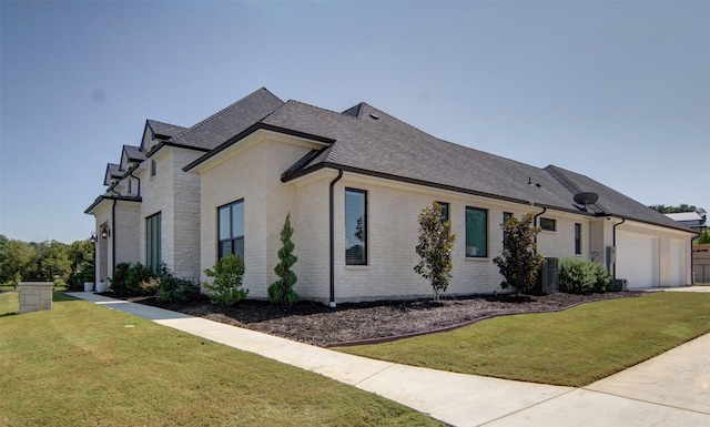 view of side of home featuring a garage and a lawn