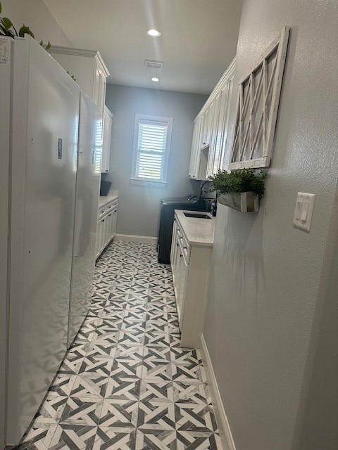 kitchen featuring white cabinets and sink