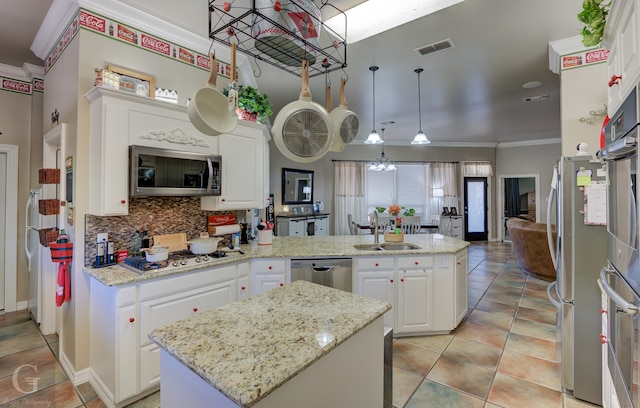 kitchen with sink, stainless steel appliances, a center island, and white cabinets