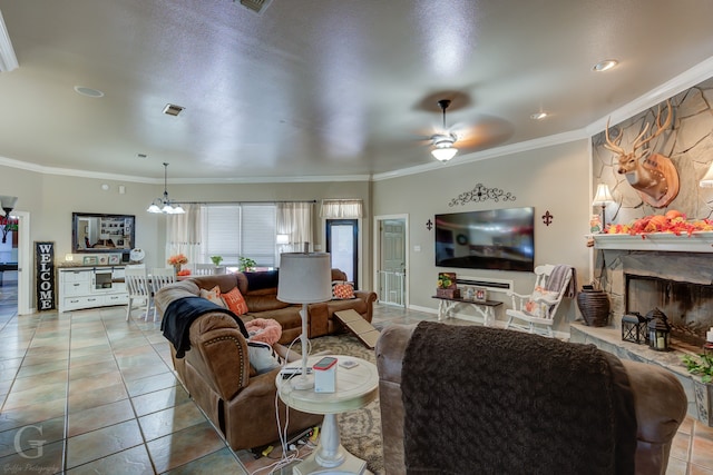 tiled living room featuring a fireplace, ceiling fan with notable chandelier, and crown molding