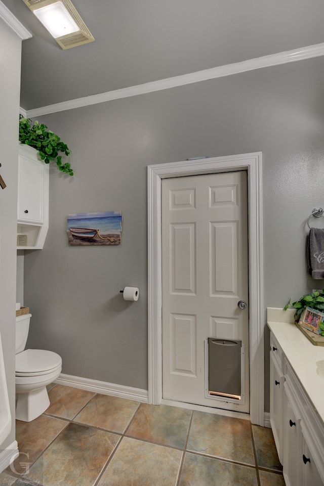 bathroom with tile patterned floors, vanity, toilet, and ornamental molding