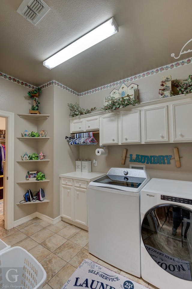 washroom featuring washer and clothes dryer, light tile patterned flooring, and cabinets