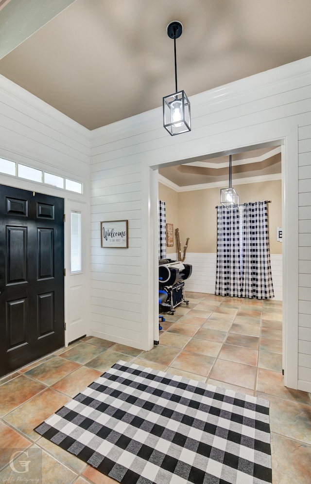 foyer entrance featuring wood walls and crown molding