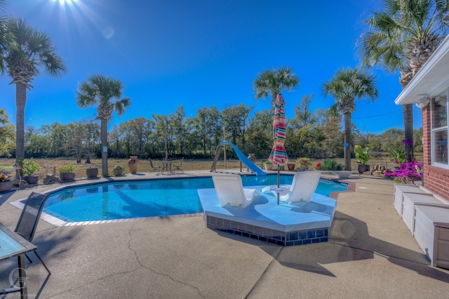 view of pool featuring a patio area and a water slide