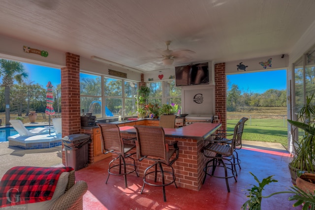 view of patio / terrace with ceiling fan and an outdoor bar