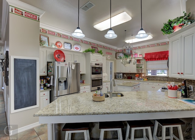 kitchen with appliances with stainless steel finishes, crown molding, and a kitchen breakfast bar